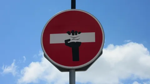 A street sign showing a hand grabbing a rectangle. Illustrates [alt text].