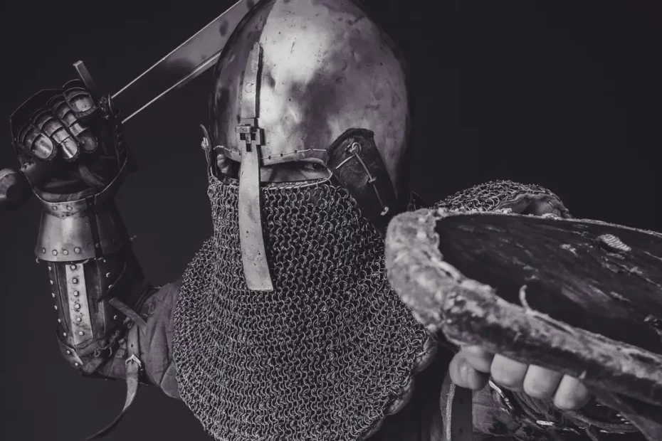 A black and white photo of a man wearing plate armor while charing for an attack with a sword and shield. Illustrates [alt text].