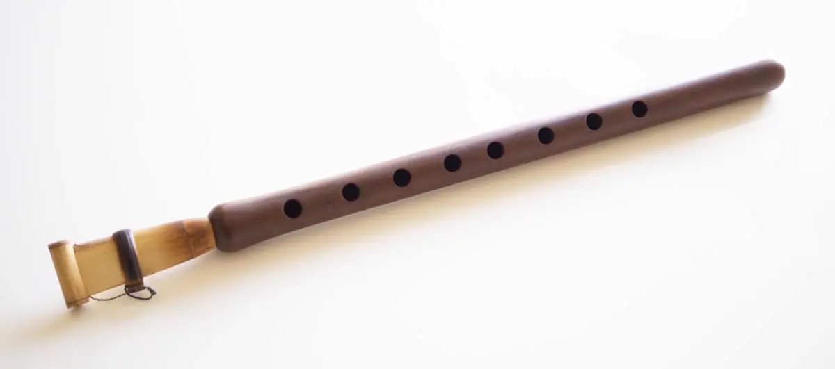 A photo of the Armenian instrument duduk on a white surface. Illustrates [alt text].