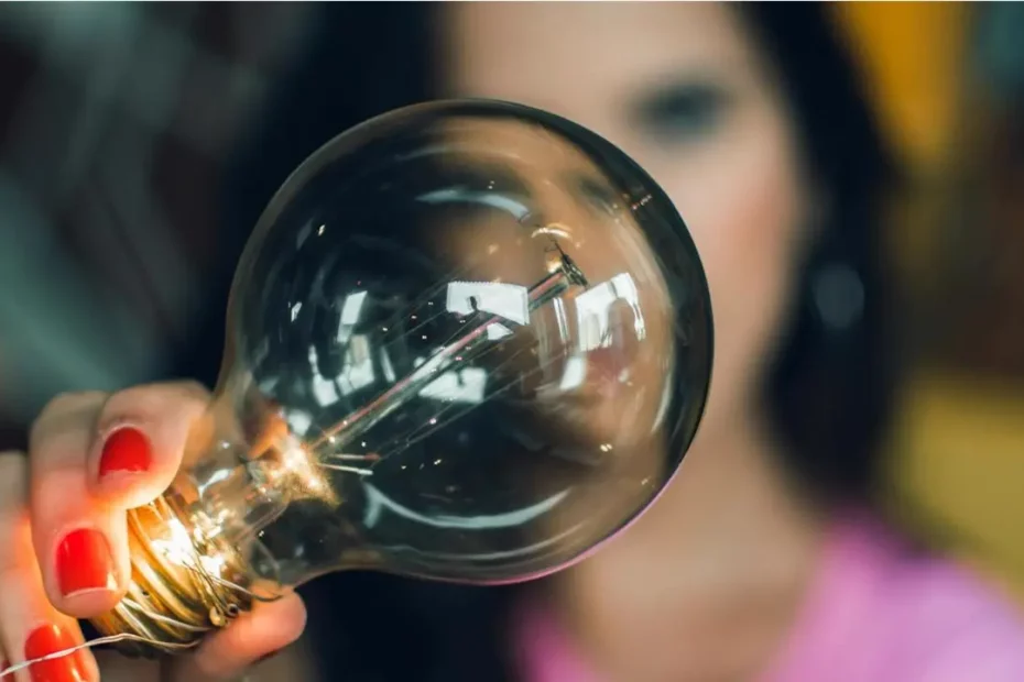 A photo of a woman holding a lightbulb. Illustrates [alt text].