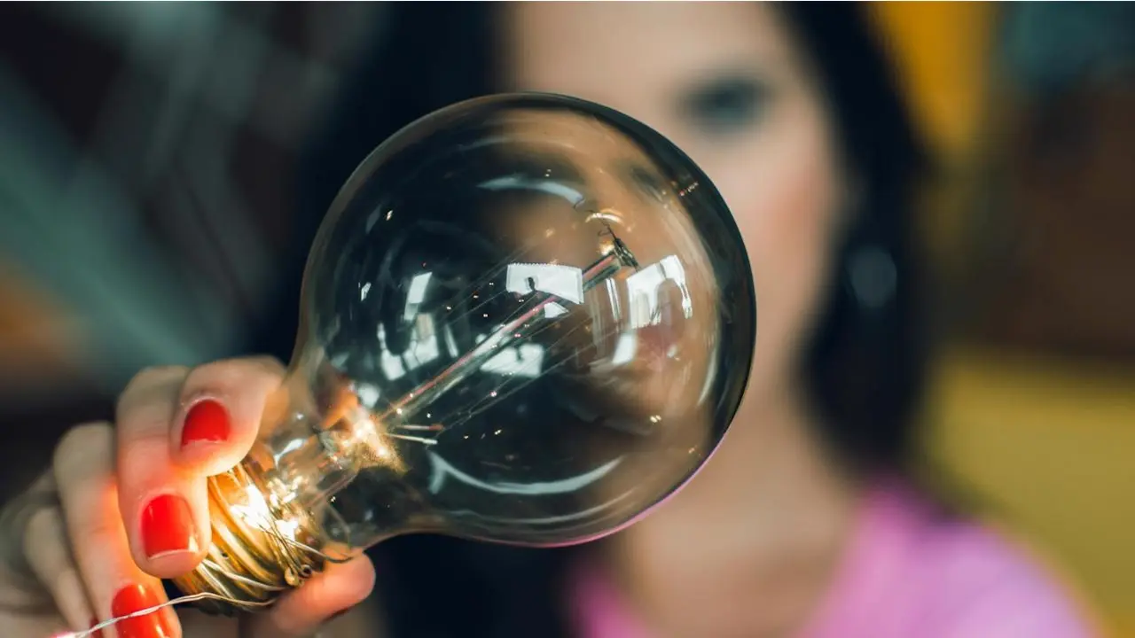 A photo of a woman holding a lightbulb. Illustrates [alt text].