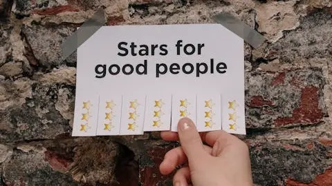 A photo showing a person gripping a paper written "stars for good people." Illustrates [alt text].