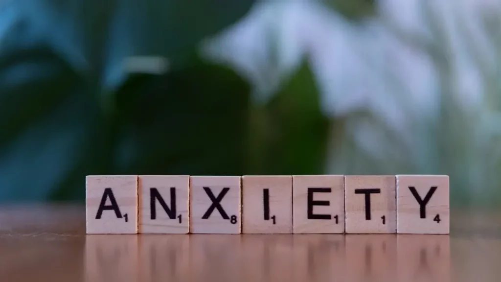 a-wooden-block-spelling-the-word-anxiety-on-a-table A wooden block spelling the word anxiety on a table. Themes of social anxiety.
