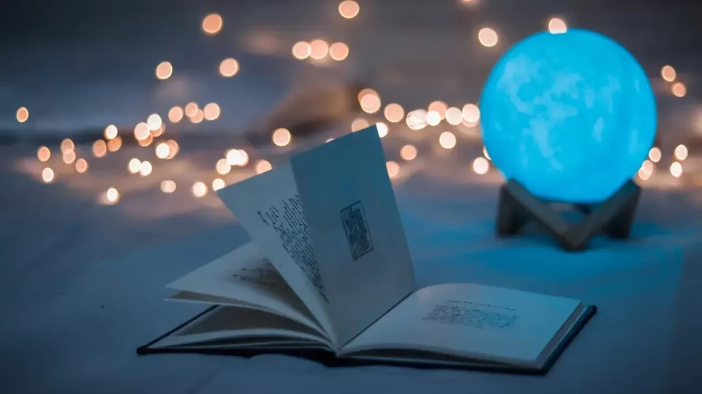 Opened book beside crystal ball. Themes of 2024 Dungeon Master's Guide.