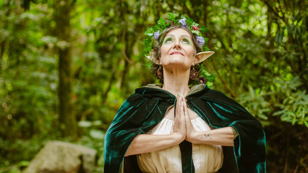 Fantasy elf woman in lush forest setting.