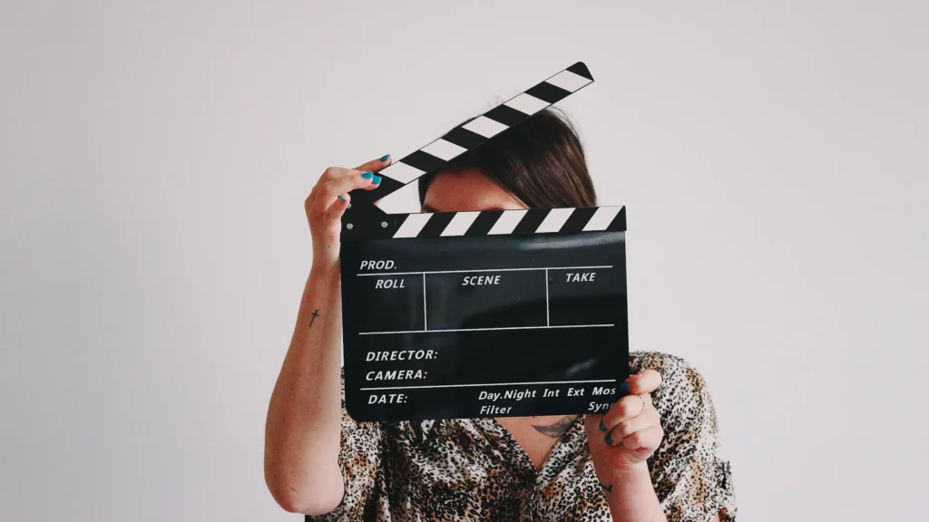 A woman holding a clapper over her face