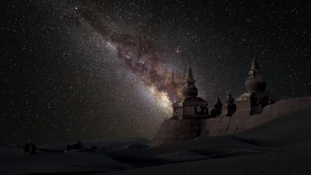Photo of a nightsky of a temple of the stars with the Milky Way visible behind it