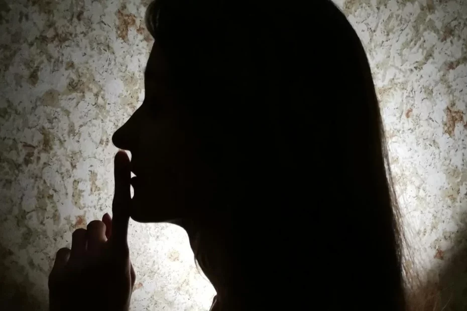 Photo of a woman wanting to use silence in a dark room.