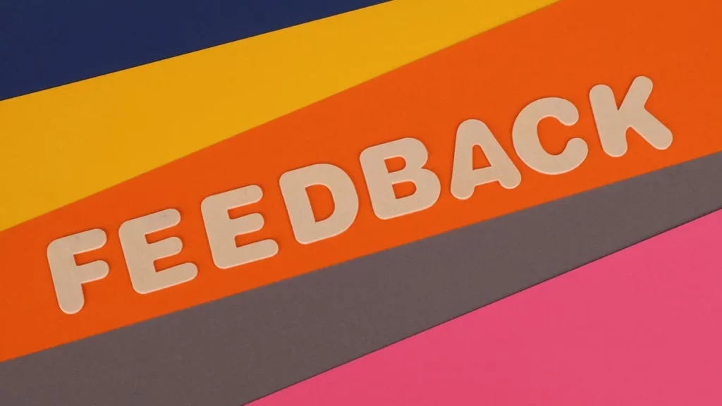 Photo of the word feedback on a brightly multi-coloured background.
