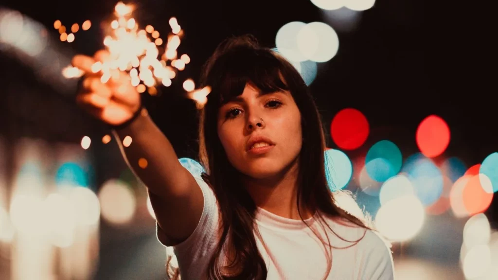 Photo of a woman holding up a sparkler.