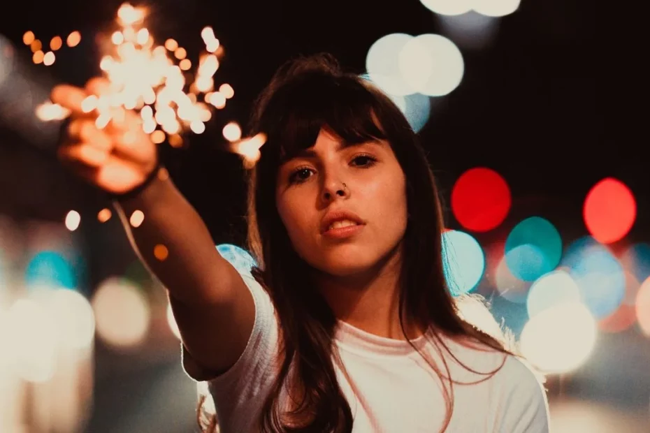 Photo of a woman holding up a sparkler.