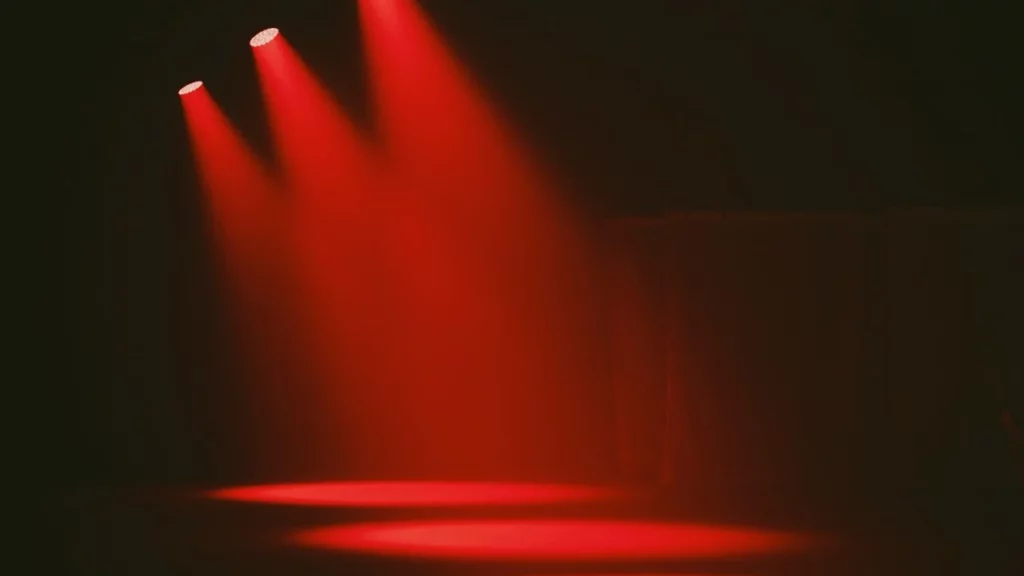 A photo of three red spotlights in the dark.